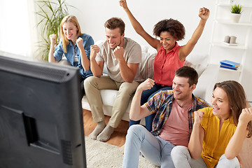 Image showing happy friends with remote watching tv at home