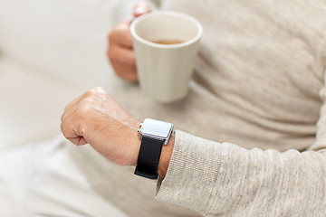 Image showing close up of senior man with tea and wristwatch