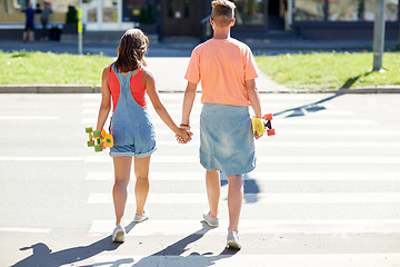 Image showing teenage couple with skateboards on city crosswalk