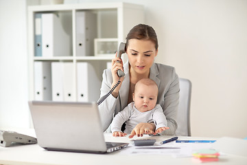 Image showing businesswoman with baby calling on phone at office