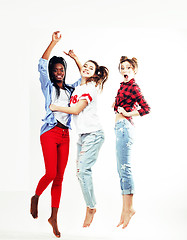 Image showing three pretty young diverse nations teenage girl friends jumping happy smiling on white background, lifestyle people concept 