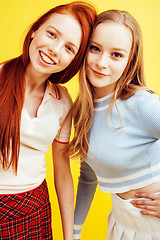 Image showing lifestyle people concept: two pretty stylish modern hipster teen girl having fun together, happy smiling making selfie close up on yellow background