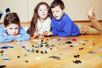 Image showing funny cute children playing lego at home, boys and girl smiling, first education role lifestyle