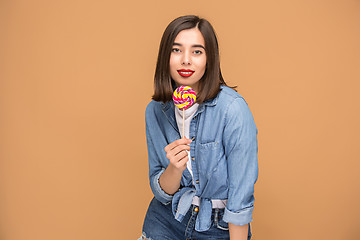 Image showing The young woman with colorful lollipop