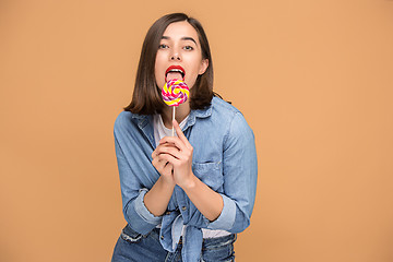 Image showing The young woman with colorful lollipop