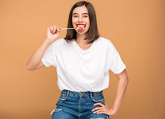 Image showing The young woman with colorful lollipop