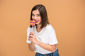 Image showing The young woman with colorful lollipop