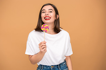 Image showing The young woman with colorful lollipop