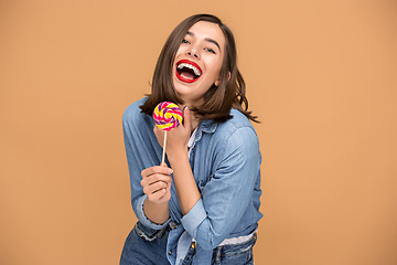 Image showing The young woman with colorful lollipop