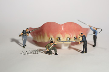 Image showing Miniature Workers Performing Dental Procedures. Dental Office Ar