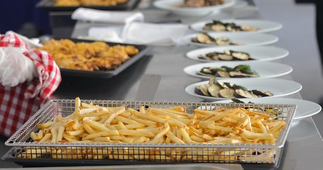 Image showing French fries and meat on the table