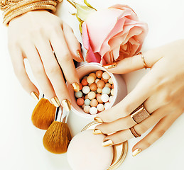 Image showing woman hands with golden manicure and many rings holding brushes,