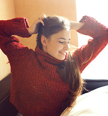 Image showing young pretty real woman in red sweater and scarf all over her fa