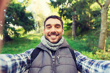 Image showing happy man with backpack taking selfie and hiking