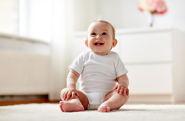 Image showing happy baby boy or girl sitting on floor at home