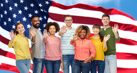 Image showing international people waving hand and american flag