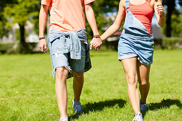 Image showing happy teenage couple walking at summer park