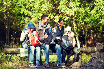 Image showing happy family with backpacks and thermos at camp