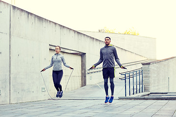 Image showing man and woman exercising with jump-rope outdoors