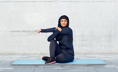 Image showing muslim woman doing sportand stretching on mat