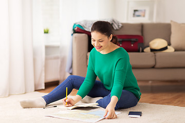 Image showing woman with notebook and travel map at home