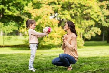 Image showing girl giving with flowers to mother in summer park