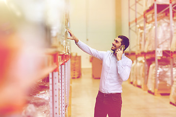 Image showing happy man calling on smartphone at warehouse