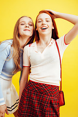 Image showing lifestyle people concept: two pretty stylish modern hipster teen girl having fun together, happy smiling making selfie close up on yellow background