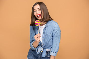 Image showing The young woman with colorful lollipop