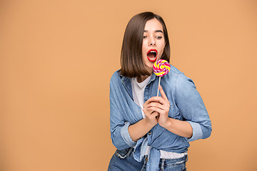 Image showing The young woman with colorful lollipop