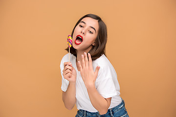 Image showing The young woman with colorful lollipop