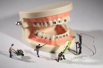 Image showing Miniature Workers Performing Dental Procedures. Dental Office Ar