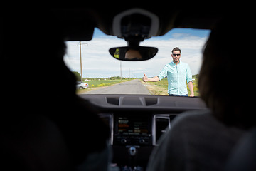 Image showing man hitchhiking and stopping car with thumbs up