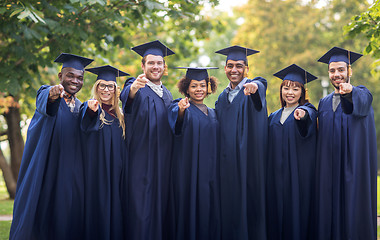 Image showing happy students or bachelors pointing finger at you