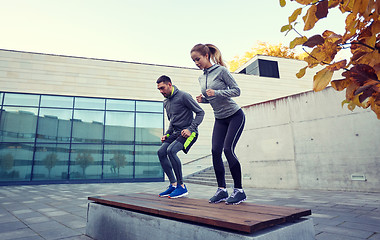 Image showing man and woman exercising on bench outdoors