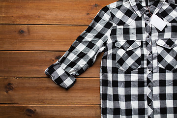 Image showing close up of checkered shirt on wooden background