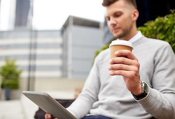 Image showing man with tablet pc and coffee cup on city street
