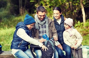 Image showing happy family with backpack and thermos at camp