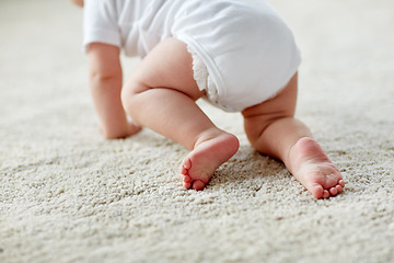 Image showing little baby in diaper crawling on floor at home