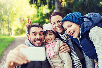 Image showing family with backpacks taking selfie by smartphone