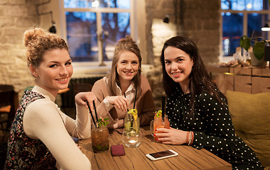 Image showing happy friends with drinks at restaurant
