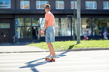 Image showing teenage boy on skateboard crossing city crosswalk