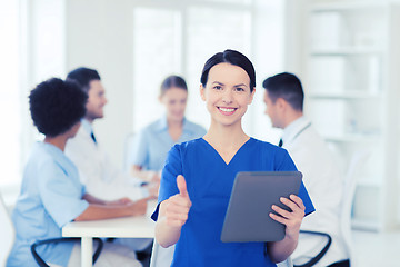 Image showing happy doctor with tablet pc over team at clinic