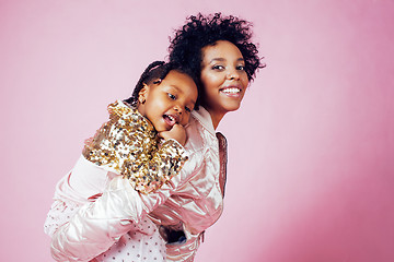 Image showing young pretty african-american mother with little cute daughter hugging, happy smiling on pink background, lifestyle modern people concept 