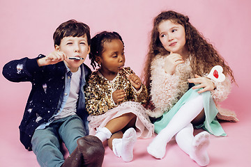 Image showing lifestyle people concept: diverse nation children playing together, caucasian boy with african little girl holding candy happy smiling 