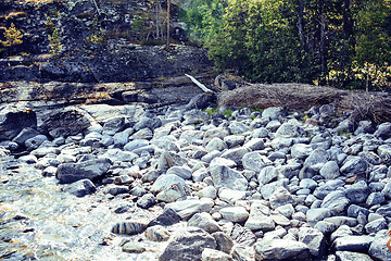 Image showing wild north nature landscape. lot of rocks on lake shore