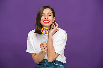 Image showing The young woman with colorful lollipop