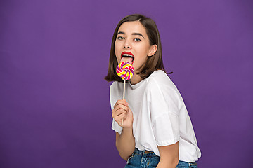 Image showing The young woman with colorful lollipop