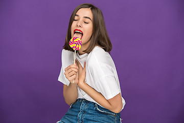 Image showing The young woman with colorful lollipop