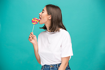 Image showing The young woman with colorful lollipop